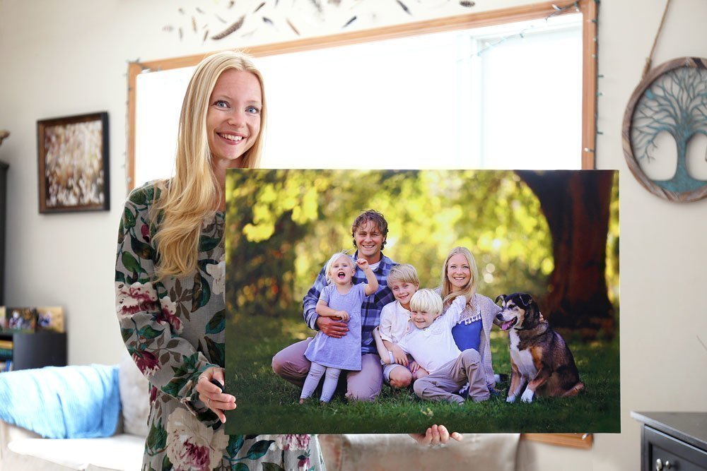 Femme avec une grande photo de famille dans les mains.